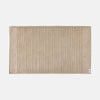Beige textured bath mat on a white background