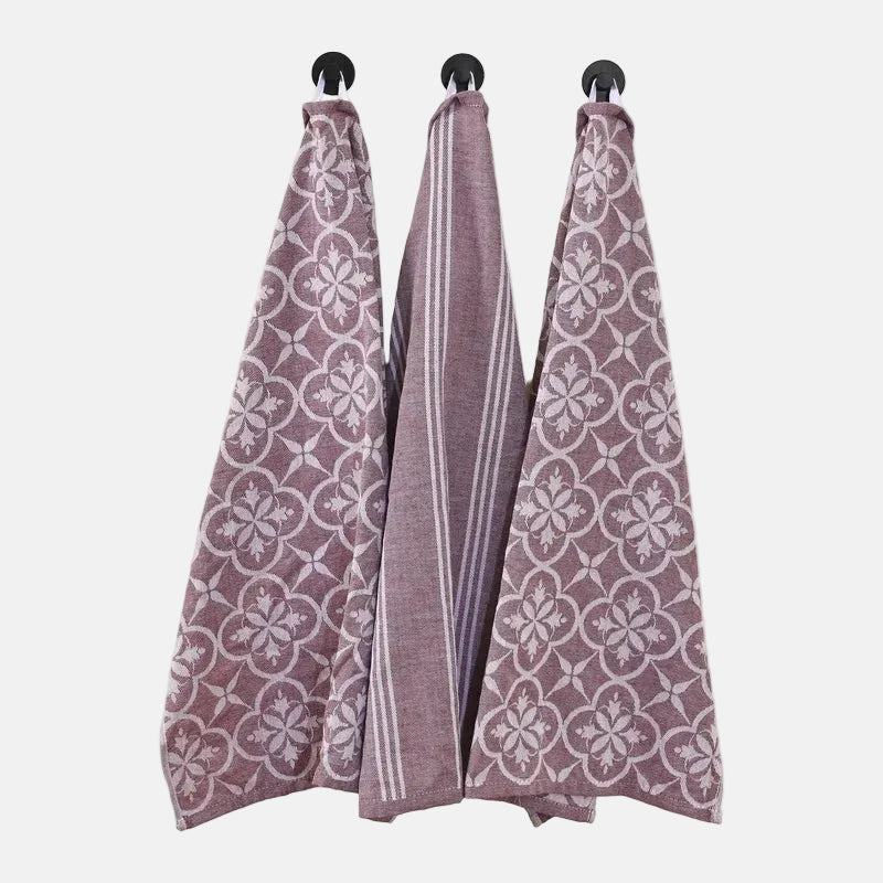 Three patterned towels hanging on a white background