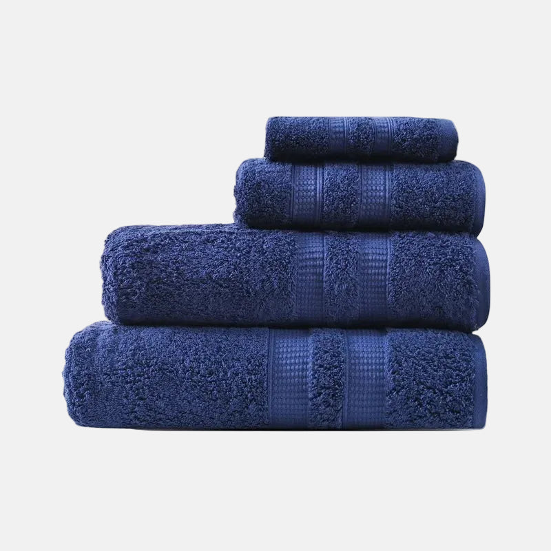 Set of four blue towels stacked on a light purple background