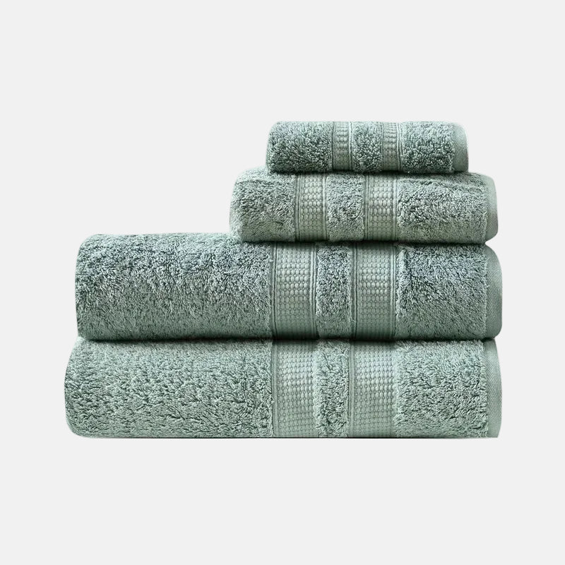 Set of four green towels stacked on a white background